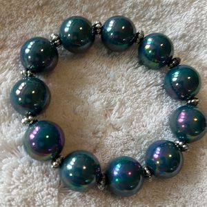 Garold Miller stretch bracelet with silver separators. Incandescent blue/green